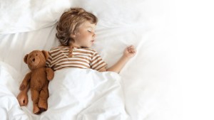 sleeping child with teddy